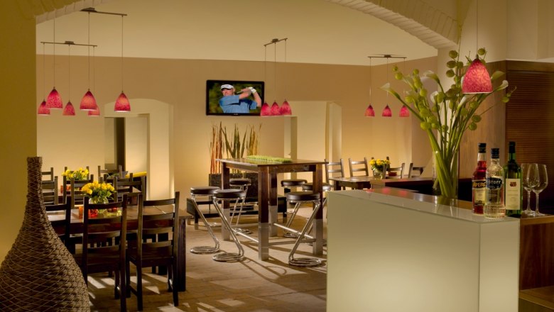 C&C Golfclub Richardhof, © C&C Golfclub Richardhof Innenansicht eines stilvollen Restaurants mit modernen Möbeln und roten Hängelampen.