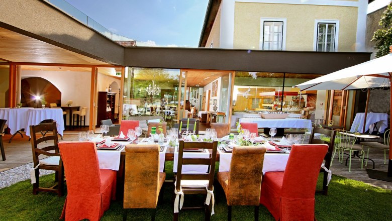 Elegantes Restaurant mit gedecktem Tisch im Freien, umgeben von modernen Gebäuden.